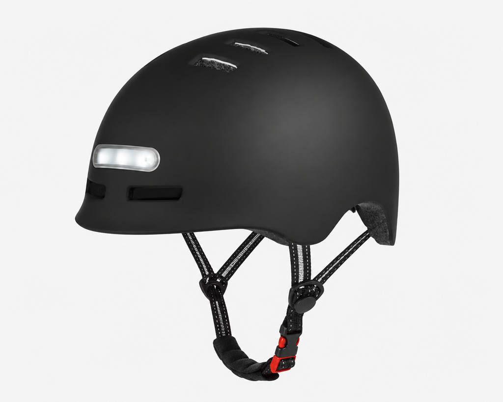 A matte black bicycle helmet with a front light bar and black adjustable straps, shown against a light gray background.